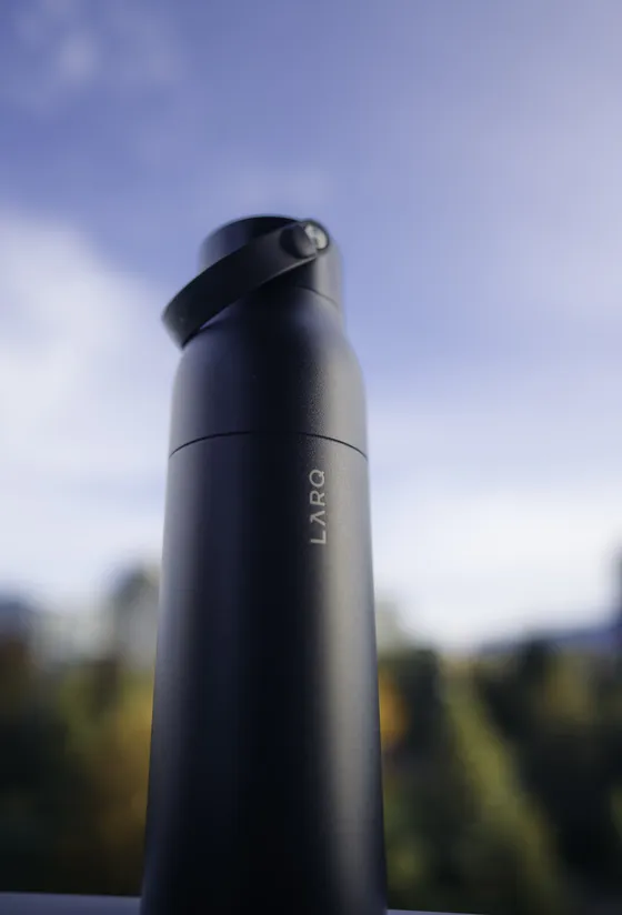 LARQ water bottle shot against blue sky, wide aperture