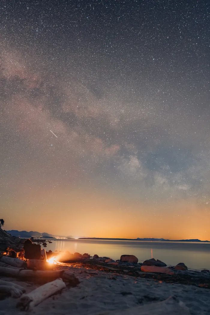 Campfire on Savary Island beach with Milky Way galaxy overhead BC night photography